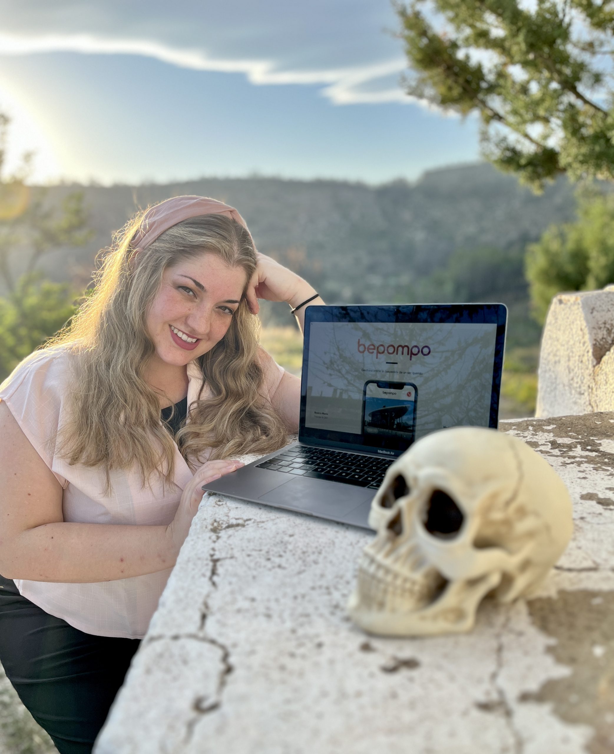 Bea Marín, fundadora de Beatomik, sonriendo junto a su portátil en un mirador de Torás